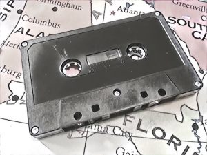 Black & white image of a cassette tape on a map of the US.