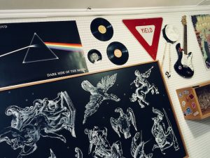 In-game: a 90s bedroom with Pink Floyd album art, a zodiac poster, records, and a guitar.