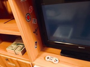 In-game: a TV and game console in a 90s bedroom.