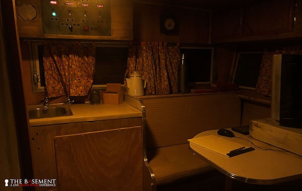 In-game: a small kitchenette and table in a quaint trailer.