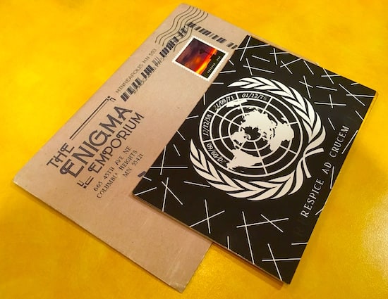 The Enigma Emporium envelope and a UN postcard.