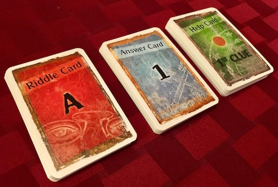 The riddle cards, answer cards, and help cards decks.