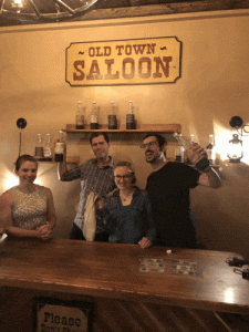 Animation of post-game team photo in a saloon with David making a silly liquor swig motion.