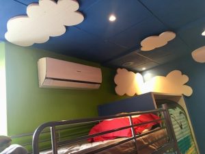 In-game: Nicolai's bunk bed and air conditioner. His ceiling is painted blue with large styrofoam clouds.