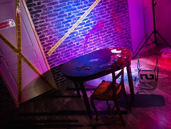 In-game: A well lit movie set of a crime scene around a poker table.