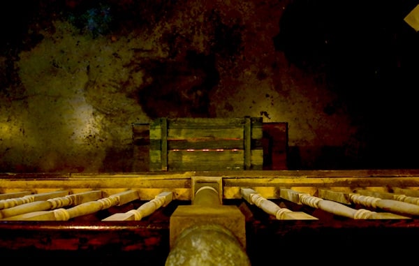 In-game: View over the balcony to a wooden box with a faint red glow emanating from it.