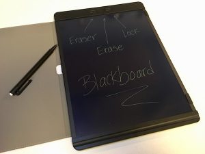 A large boogie board blackboard, pointing out the eraser button, the erase button, and the lock switch.