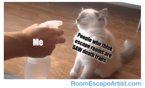 Meme: A hand holding a spray bottle of water labeled, "Me." A cat being sprayed and looking dismayed labeled, "People who think escape rooms are SAW death traps."