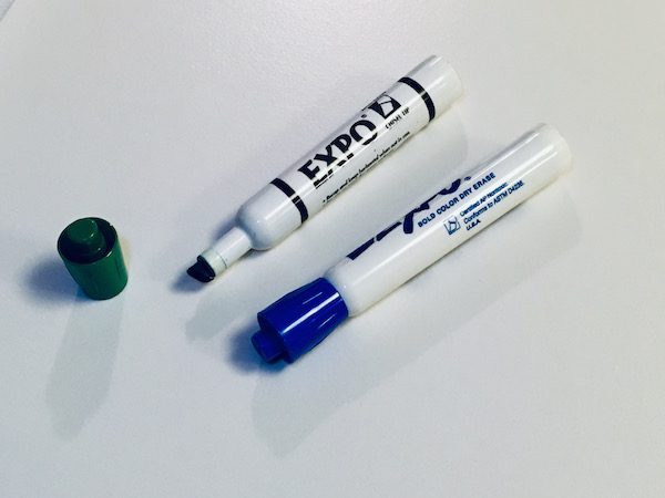 Dry erase markers on a whiteboard.