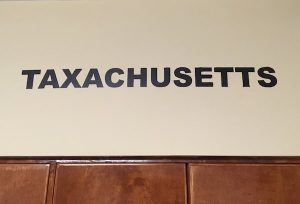 In-game: the word "Taxachusetts" painted boldly on the wall.