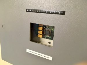 In-game: Close up of the electronic surveillance system box.