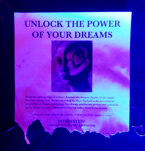 In-game: A poster telling the reader to "Unlock the power of your dreams." It has a trippy image of heads within heads.