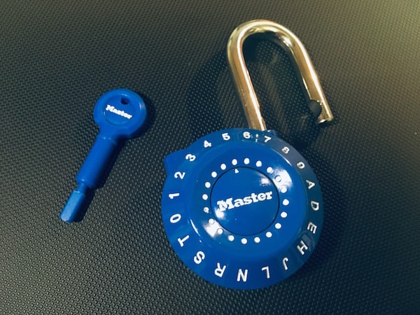 Blue alphanumeric locker-style padlock open with a reset key sitting beside it.