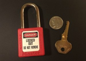 Red Master Lock 410 beside its brass key and a quarter for size reference.