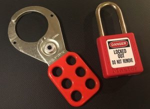 A lockout tagout hasp next to a red Master Lock 410.