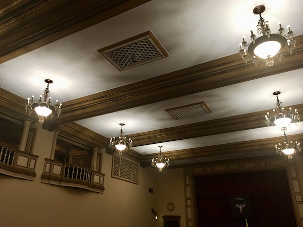In-game: The ceiling of the ballroom features beautiful woodwork and intricate light fixtures.