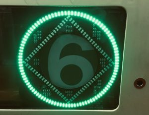 A glowing green 6 train sign.