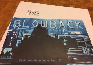 The "Blowback: Wish You Were Here Part II" envelope depicts a black hoodied hacker in front of many computer monitors.