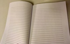A blank notebook with horizontal rules.
