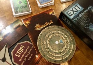 An assortment of game components, an answer disk, a booklet, a map, and 3 decks of cards.