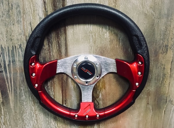 In-game: closeup of a steering wheel.