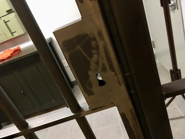 In-game: Close up of the steel bars and keyway on the cell door.