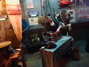 In-game: A marketplace table with an actor looking at the products.