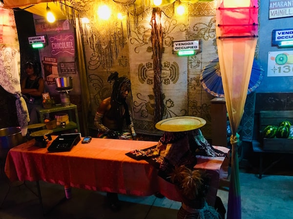 In-game: A marketplace table with an actor setting up shop.