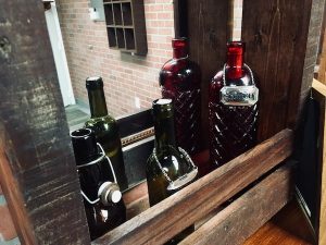 In-game: Closeup of a small bar featuring old liquor bottles.