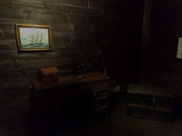 In-game: The captain's desk and a locked chest aboard a pirate ship.