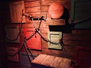 In-game: A series of wooden doors linked by a heavy steel chain.