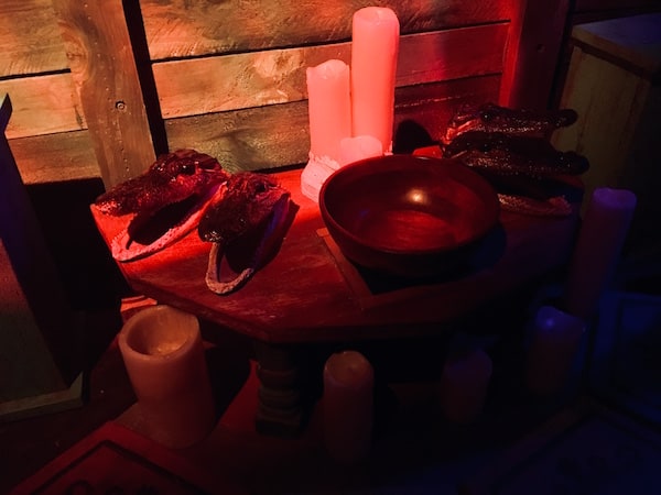 In-game: small alligator heads and candles arranged in a shrine.