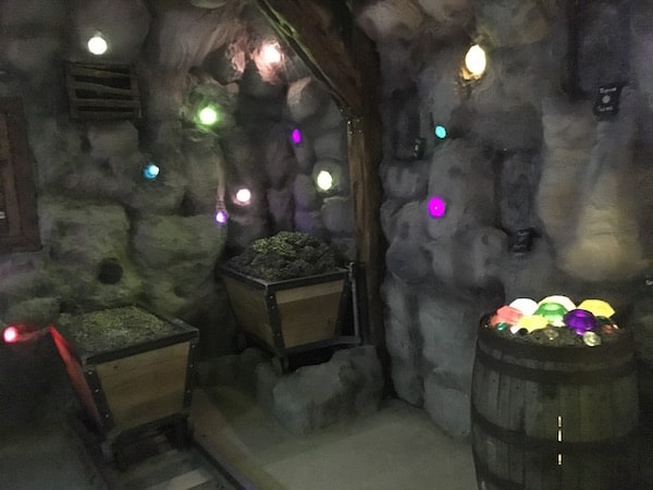 In-game: A gem mine with mining carts, and gems protruding from the walls and ceiling.