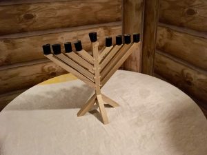 In-game: A wooden menorah on a table in a cabin.