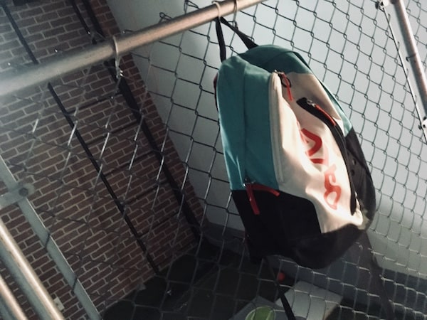 In-game: A schoolyard fence with with a bookbag hanging from it.