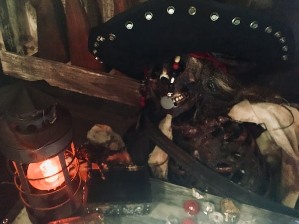 In-game: a dead and decaying pirate captain surrounded by treasure.