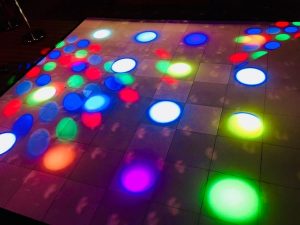 In-game: a dance floor with colored lights shining on it.