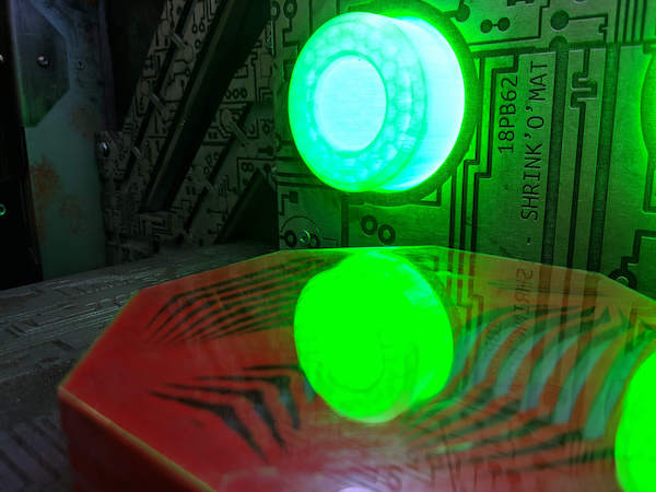 In-game: Closeup of a circuit board with a large glowing green LED.