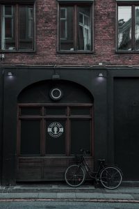 A side of a building with a bicycle leaning against it.