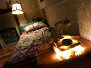 In-game: A glowing rotary phone ad the foot of a bed.