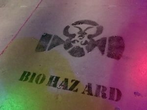 In-game: "Biohazard" and an image of a gasmask painted in black on concrete.