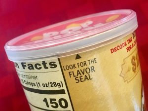 The sealed top of the Mystery Flavor Pringles tube. The words, "Look for the flavor seal" are centered in frame.