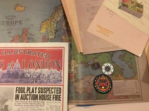 A newspaper, a map, a poker chip, an a patch with a South American-esque design.