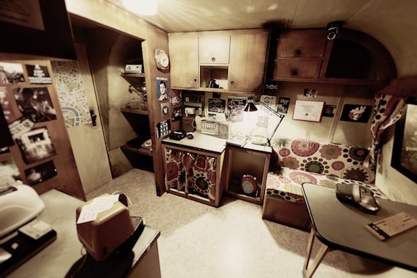 In-game: the inside of Ernie Hudson's mobile home filled with his gadgets, degrees, and ugly print patterns on his couch.