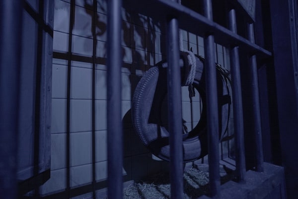 In-game: A tire swing hanging in a sad, dark cage.