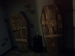 In-game: A pair of old, worn coffins leaning against the wall.