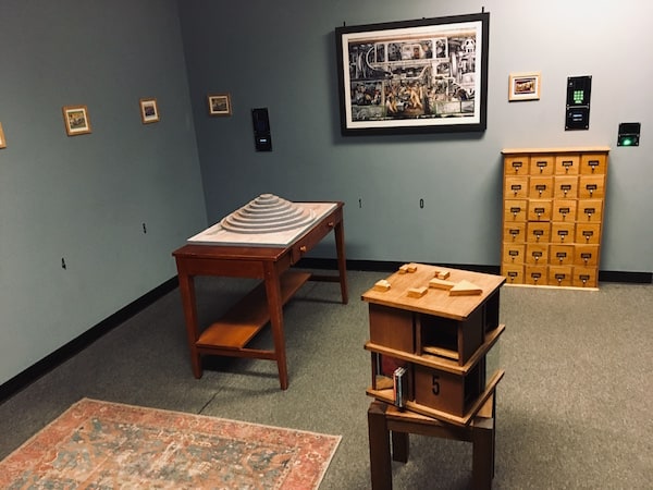 In-game: wide shot of the puzzle room with three set pieces in view.