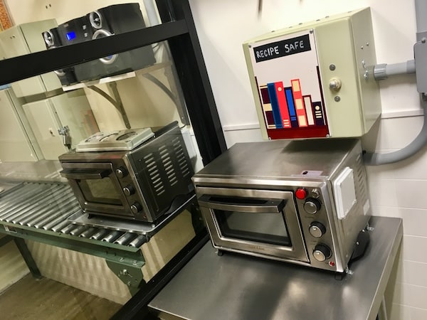 In-game: a small oven in a kitchen, above it a box labeled "Recipe Safe."