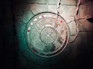 In-game: A gold Mayan sculputre engraved and hanging from the wall of the tomb.