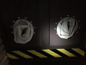 In-game: Closeup of mounted box gloves for handling hazardous materials.